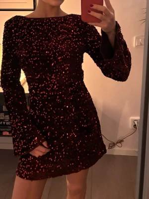 Vinröd paljettklänning med öppen rygg - (FRI FRAKT!!) Super fin till nyår, mörkröd med paljetter, vida armar och öppen rygg, inte alls stickig då det finns en underklänning❤️storlek XS. 