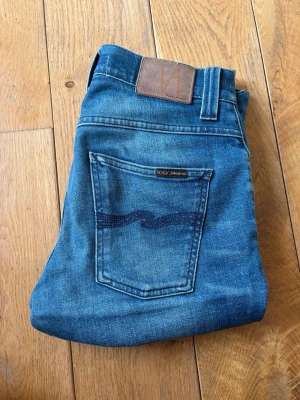 Nudie Jeans Grim Tim - Säljer ett par riktigt feta Nudie jeans av modellen Grim Tim som är i mycket bra skick. Sjukt bra passform och de är w29 som står i byxorna. De är L32 i längd. Riktigt feta och mycket fräscha. Hör av er vid frågor. 