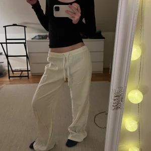 Linnebyxor med snörning från Pull&Bear - Säljer ett par ljusa linnebyxor från Pull&Bear i storlek S. Byxorna har en avslappnad loose passform, elastisk midja med snörning och är tillverkade i mjukt linne. 
