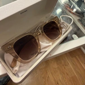 04or CHIMI - Snygga solglasögon från CHIMI med transparent beige båge och fyrkantig form. Glasen är bruna och ger en cool vibe till din look. Kommer med originaletui och påse. Perfekta för dig som vill sticka ut med stilrena accessoarer.