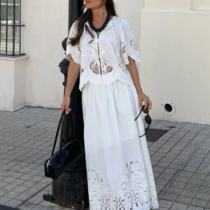 Vit topp och kjol med broderade detaljer - Superfin vit topp med matchande kjol från Nakd med broderade spetsdetaljer och snörning framtill. Toppen har korta ärmar med vackert mönstrade utskärningar och en kjol med broderad kant. Perfekt för sommarens alla tillfällen!🌸🩷 både kjol och topp är i storlek 34