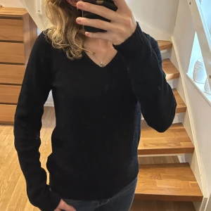 Svart v-ringad stickad tröja från Vila - Svart stickad tröja från Vila med v-ringning och långa ärmar. Enkel och stilren modell med ribbade muddar vid ärmslut och nederkant. Perfekt till hösten och vintern🤎