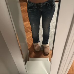 Lågmidjade blå jeans med slitningar - Säljer ett par blå jeans med låg midja och snygga slitningar på benen. Perfekt för dig som gillar en avslappnad och chill jeans❣️❣️