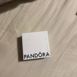 Pandora silverring med hjärta - Säljer en snygg silverring från Pandora med ett stort hjärtformat klara sten i mitten och mindre stenar runt om. Ringen har glittriga detaljer längs hela bandet och kommer i original ask. Perfekt för dig som gillar bling och romantisk stil.