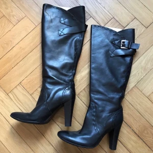 Italienska stövlar i skinn  - Fantastiska höga boots från italienska märket Vero Cuoio i äkta kalvskinn. Snygga detaljer med spänne och dekorativa sömmar. Går strax under knäna på mig som är 160cm. Knappt använda då jag fick dem i present men de blev för stora (jag har 37). Några små repor på ytan som kan bli, annars toppenskick! Nypris runt 6000kr.