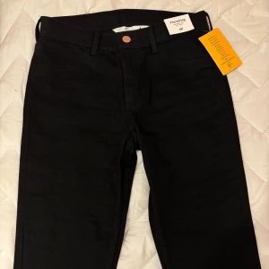 Svarta bootcut jeans från H&M - Svarta jeans från H&M med bootcut-modell. Byxorna har låg midja och är tillverkade i ett stretchigt bomullsmaterial för skön passform. Perfekta för dig som gillar en tidlös look med lite extra vidd nertill.