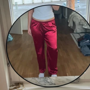 Röda silkes pyjamasbyxor  - Röda silkes pyjamasbyxor i strl M/L. Helt oanvända! Resår i midjan. Står inget märke
