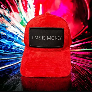Röd keps TIME IS MONEY sammet - Riktigt snygg röd keps i sammet med svart patch framtill där det står 'TIME IS MONEY' i vitt. Kepsen har klassisk böjd skärm och cool streetkänsla. Perfekt statement-piece för dig som vill sticka ut.