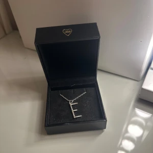Silverhalsband Maria Nilsdotter bokstav E - Jag säljer ett jätte fint Maria Nilsdotter halsband som är använd men har tagits han om väl så finns inga skador eller defekter på halsbandet. Halsbandet är i storlek 50❣️❣️