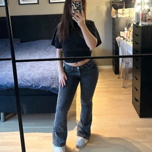 Bootcut jeans med låg midja från Gina Tricot - Snygga mörk gråa bootcut petit jeans med låg midja och klassisk femficksdesign. Jeansen har en mörk tvätt och är tillverkade i jeansmaterial med stretch för skön passform. Perfekta för dig som gillar en retro vibe och vill ha ett par jeans som sitter tajt upptill och har utsvängda ben. Ny pris 499kr