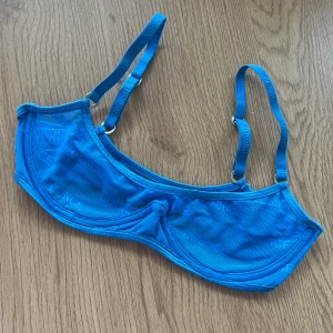 Lounge BH 💙 - Snygg blå mesh-bh från Lounge i storlek XS. Den har justerbara axelband och är tillverkad i ett lätt och luftigt material med Lounge-loggan diskret tryckt över hela tyget <3