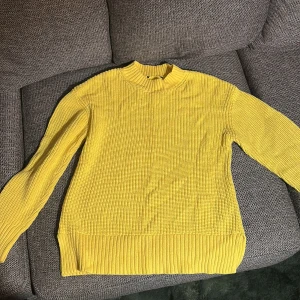 Gul stickad tröja - Snygg gul stickad tröja med ribbad kant vid halsen, ärmsluten och nederkanten. Tröjan har en klassisk rund hals och långärmade armar. Asfin att ha på stan o till skola men jätteskön att ha hemma (inte kliig alls)
