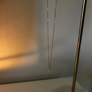 Silverhalsband med rund klar sten - Ett stilrent halsband i silver med en tunn kedja och ett runt hängsmycke med en klar, gnistrande sten🌟