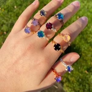 Enkla ringar med färgglada stenar - Unika handgjorda ringar med stora, runda stenar i olika färger som blå, röd, lila, grön, svart och guld. Ringarna har snygga wire-detaljer i guld- och silverfärgad metall. Perfekt för dig som vill sticka ut med färg och cool design. Finns i silver, guld, koppar eller bronsfärgad metall. 