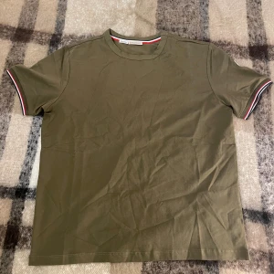 Moncler t-shirt Olivgrön - Olivgrön t-shirt från Moncler i 💯bomull. Modellen➡️Moncler Maglia T-shirt, den är nyskick aldrig använd. Storlek S. vid intresse eller frågor är det bara höra av dig. Originallappar medföljer vid köp🙌, priset kan diskuteras❗️ inom snabbaffär eller bundleköp.