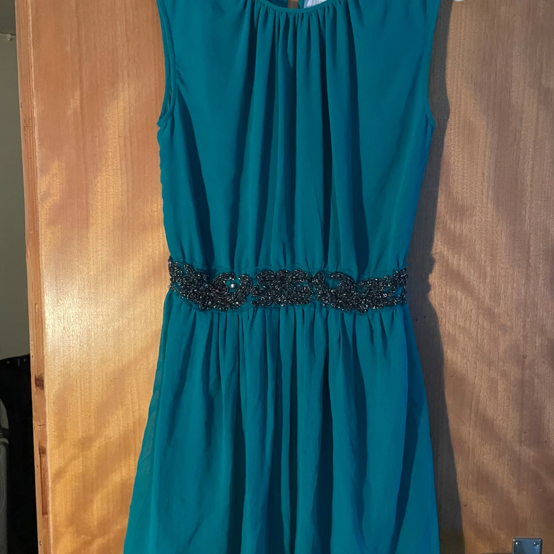 Turkos kortklänning med pärldetaljer