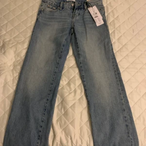 Perfect Jeans Scandi Low Petite blå jeans - Snygga ljusblå jeans från GinaTricot, modell Scandi Low Petite. De har låg midja, raka ben och klassisk femficksdesign. Materialet är mjukt denim i bomull och passformen är straight. Perfekt för dig som gillar en enkel och clean look.