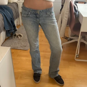 Ljusblå bootcut jeans - Midjemått: 36cm tvärsöver, innerbensläng: 84cm. Lite slitna längst ned, lagade i skrevet samt insydda i midjan!
