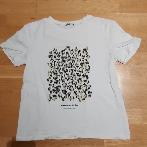 Vit t-shirt med leopardmönster från Zara - Vit t-shirt från Zara i storlek S med coolt leopardmönster i svart och beige på framsidan. Klassisk rund hals och korta ärmar. Tillverkad i mjuk bomull, perfekt för dig som gillar trendiga prints och enkel stil. Använd fåtal gånger ich i bra skick💞💞 Meddela för frågor eller eller om pris! 