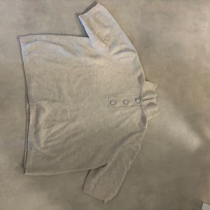 Beige polotröja med pärlknappar H&M - Snygg beige polotröja från H&M i storlek XL. Tröjan har korta ärmar och en hög krage med fyra dekorativa pärlknappar framtill. Materialet är mjukt och stickat, perfekt för dig som gillar  stilrena och enkla plagg med en twist. Den är lite nopprig men fortfarande fin. Hör av er vid frågor💕