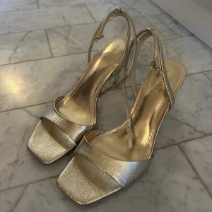 Guldiga klackar från Stradivarius - Guldiga klackar från Stradivarius! Storlek 40 och mycket bra skick, använda 1 gång. Höjd 8 cm