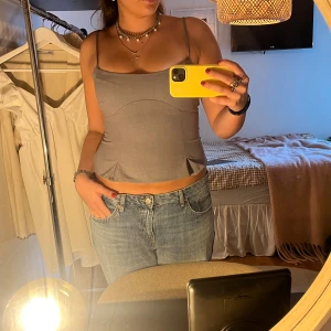 Grå korsettopp med smala axelband - Säljer denna helt nya gråa korsettopp med smala axelband och diskreta sömdetaljer framtill. Passar perfekt som festtopp och till vardags☁️☁️