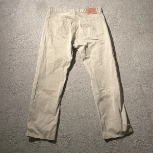 Levi's 530 beige jeansbyxor 32/32 Vintage  - Snygga Levi's 530 jeansbyxor i beige med klassisk femficksdesign och raka ben. Byxorna har en normal passform och är tillverkade i mjuk bomull. Perfekt för dig som gillar stilrena och tidlösa jeans med ikonisk Levi's-lapp bak.