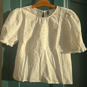 Vit blus med broderade detaljer - Säljer en söt vit blus med korta puffärmar och broderade blommönster över hela tyget💓💓