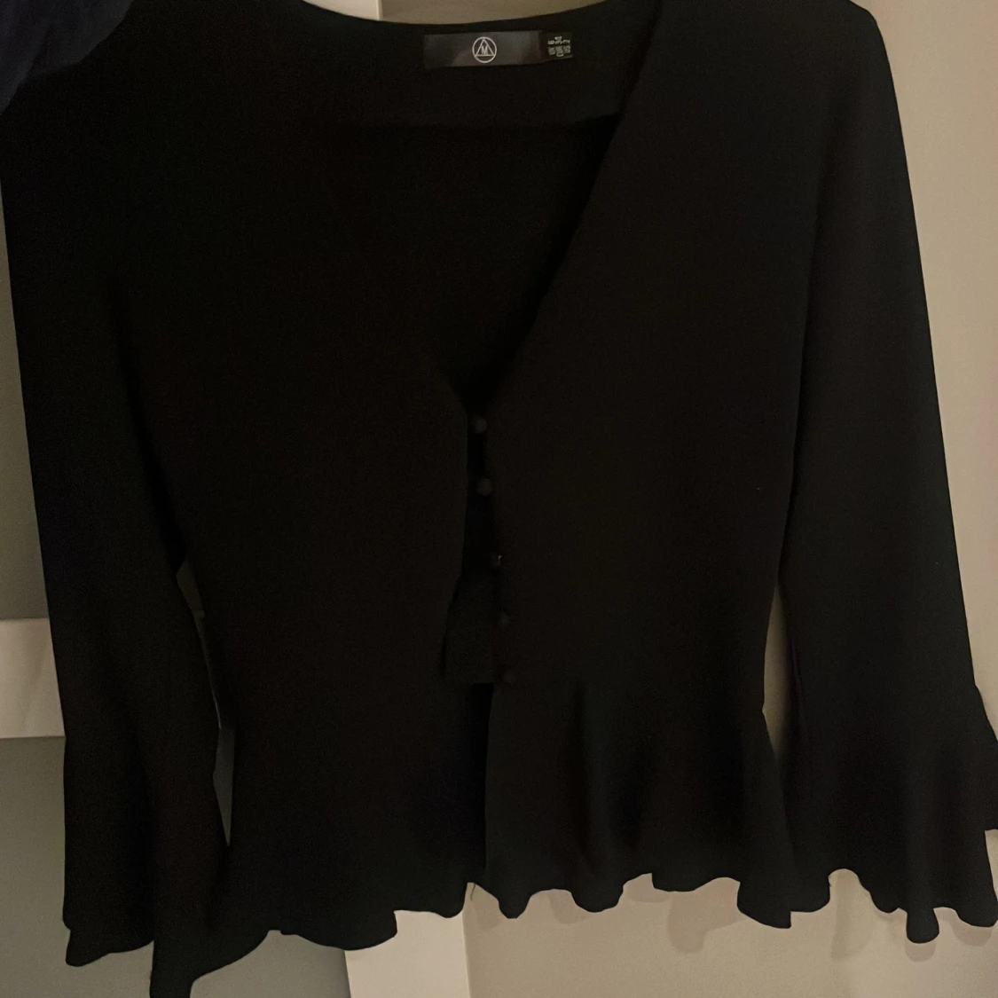 Svart blus med volang