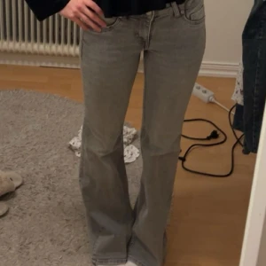 Grå lågmidjade bootcut jeans - Supersnygga low waist grå jeans i flaremodell från HM. Storlek 36. Slutsålda på hemsidan. Endast använda ett fåtal gånger💕🥰❤️
