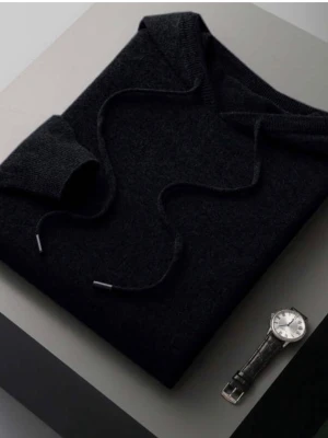 Svart hoodie i kashmire och fint cotton  - En stilren svart hoodie med huva och dragsko. Tillverkad i ett mjukt, stickat material som känns skönt mot huden. Hoodien har långa ärmar och ribbade muddar vid ärmslut och nederkant. Perfekt för en avslappnad look.