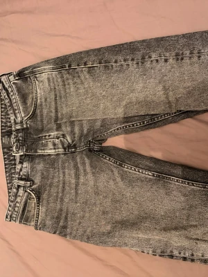 Gråsvarta slim fit jeans från NEUW - Snygga gråsvarta slim fit jeans från NEUW med klassisk femficksdesign och svarta detaljer. Jeansen har en tvättad look och raka ben. Perfekta för en trendig och avslappnad stil.