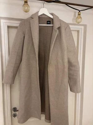Beige kappa Zara - Fin beige kappa från Zara. Säljer pga för kort i ärmarna för mig🥰