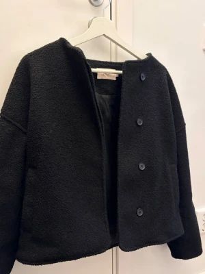 Svart kappa  - Säljer denna svarta kappan från Nelly som jag använde förra hösten ☺️ inga defekter, snygg och stilren ❣️