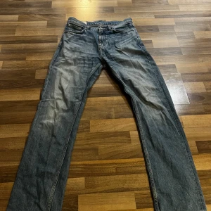 Blå raka jeans med klassisk passform - Säljer ett par blå jeans med rak passform och fem fickor. Jeansen har en klassisk look med normal midja och dragkedja fram. Perfekta för en avslappnad stil. Nypriset är 1700kr, använda fåtal gånger. Pris går att diskuteras👍