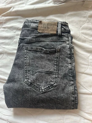 Svarta straight fit jeans Garcia - Snygga svarta jeans från Garcia Jeans i straight fit-modell med relaxed waist och raka ben. Jeansen har en cool tvättad look och klassisk femficksdesign. Perfekta för dig som gillar en avslappnad men trendig stil.