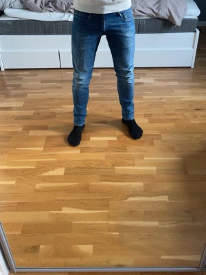 Replay Anbass jeans  - Snygga blå slim fit jeans från Replay med klassisk femficksdesign. Jeansen har en modern passform som sitter tajt över benen och är tillverkade i mjukt denim-material med stretch för extra komfort.