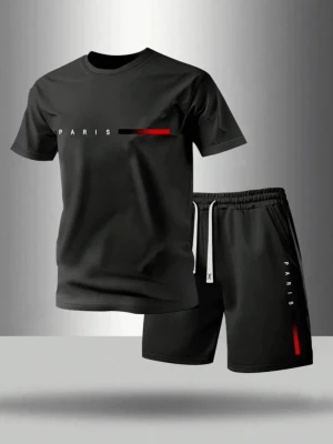 Svart set med PARIS-tryck - Snyggt svart set med t-shirt och shorts. T-shirten har ett diskret PARIS-tryck och en röd detalj på bröstet. Shortsen har matchande PARIS-tryck och röd linje på benet samt vit dragsko i midjan. Perfekt för en avslappnad och trendig look.