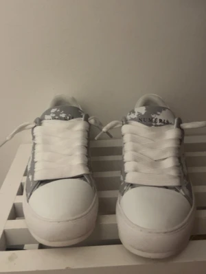 Gråvita sneakers från Numeris - Snygga sneakers från Numeris i grått och vitt med coolt camouflage-mönster. Skorna har vita snören och en chunky sula som ger en modern vibe. Perfekta för dig som vill sticka ut med din stil.