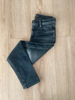 Mörkblå Replay jeans  - Snygga mörkblå jeans från Replay med tvättade detaljer och klassisk femficksmodell. Jeansen har normal passform och raka ben, perfekta till en avslappnad stil. Tillverkade i bomull för skön känsla och bra hållbarhet.