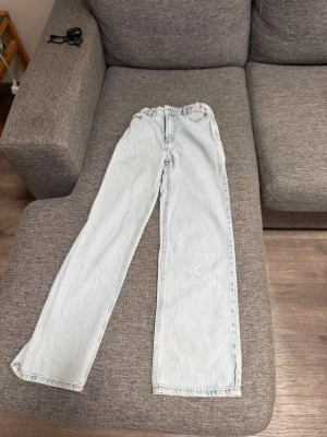 Ljusblå raka jeans i vintage-stil - Säljer ett par ljusblå jeans med rak passform och medel midja. Jeansen har klassisk femficksdesign och är tillverkade i ett robust denimtyg. De är från Lindex i storlek 152