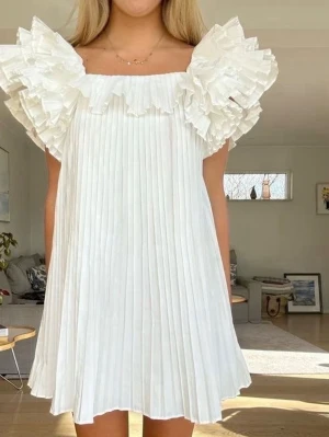 Vit plisserad kortklänning med volang - Så fin och eftertraktad klänning från Zara! Säljs inte längre, endast använd vid 1 tillfälle! Storlek xs💕 