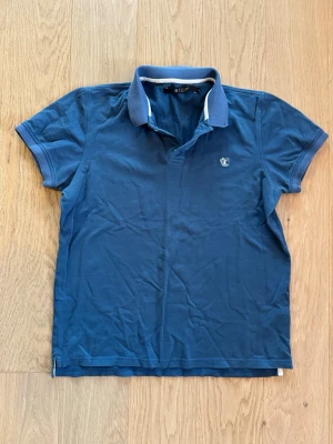 Blå piké från Tiger of Sweden - Blå piké från Tiger of Sweden i stl S. Fina detaljer på krage och armar. Så gott som ny!