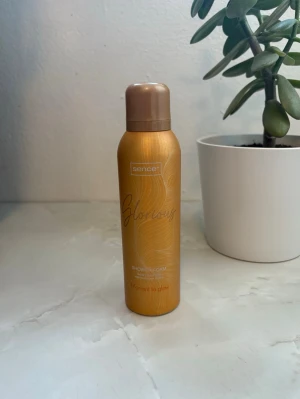 Sence Glowing Shower Foam - Sence Glowing Shower Foam i en snygg guldig flaska med bronsfärgat lock. Duschskummet har en lyxig känsla och är perfekt för dig som vill ha en fräsch och glowig start på dagen. Flaskan är smidig och lätt att ta med.