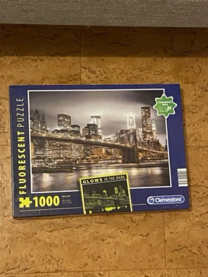 Pussel New York 1000 bitar lyser i mörkret 🧩  - Säljer ett fluorescerande pussel från Clementoni med motiv av New Yorks skyline och Brooklyn Bridge. Pusslet har 1000 bitar och lyser i mörkret. Perfekt för dig som gillar utmanande pussel och coola effekter.
