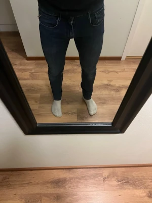 Mörkblå slim fit jeans - Säljer ett par mörkblå slim fit jeans med klassisk femficksdesign och smal passform. Jeansen har snygga kontrastsömmar och dragkedjegylf. Perfekta för dig som gillar en tajt och modern look.