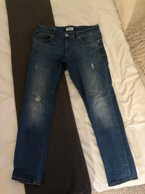 Only&sons slim jeans - Snygga blå jeans från Only & Sons med raka ben och lätt slitna detaljer på framsidan. Klassisk femficksmodell med knapp och dragkedja. Jeansen har en cool tvättad look och är perfekta för en avslappnad stil.