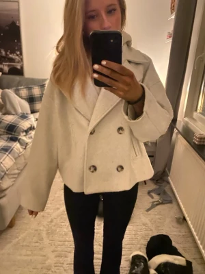 Ljusbeige kappa från stradivarius  - Snygg ljusbeige kappa från  stradivarius, dubbelknäppning och bred krage.  Jackan är lite nopprig men utöver det så är den i bra skick. 