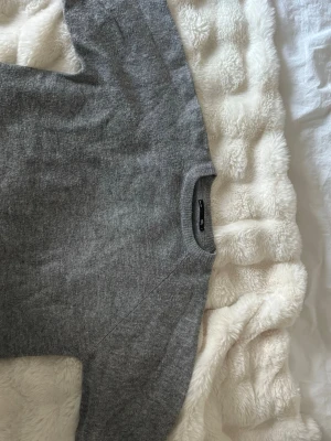 Grå stickad tröja  - Kortärmad eller trekvartsärmad stickad tröja från lager157, bra skick. Passar både under sommaren och på kallare dagar. 