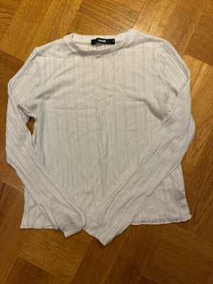 Vit ribbad långärmad tröja BikBok - Snygg vit långärmad tröja från BikBok med ribbat mönster. Perfekt basplagg  och mjukt material.